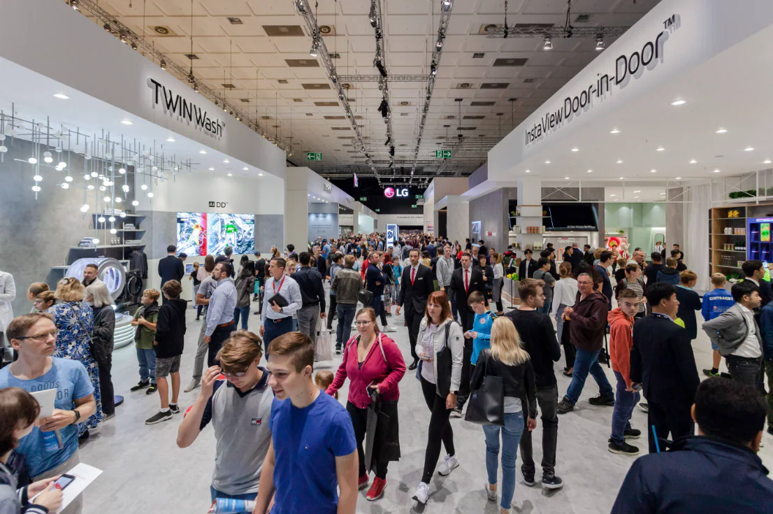 выставочный зал IFA с демонстрацией бытовой техники и посетителями.